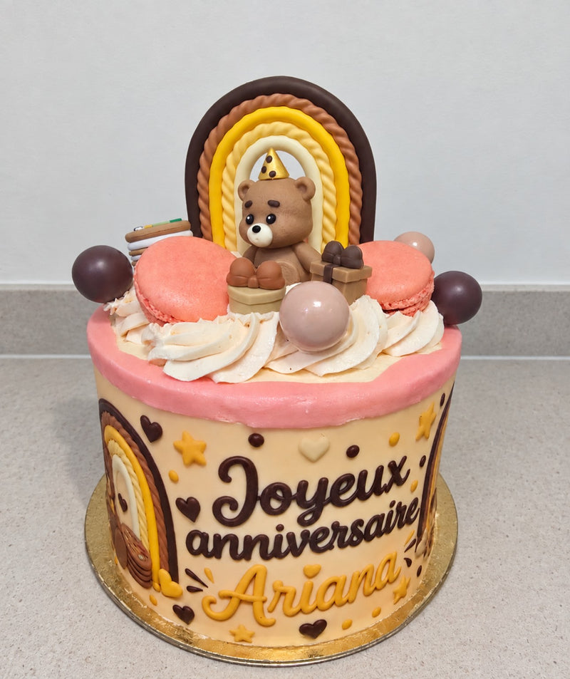 Photo comestible personnalisée « Joyeux anniversaire Ariana » autour d’un gâteau thème nounours et arc-en-ciel. Gâteau et décorations non inclus.